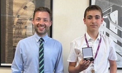 Mr Gilford and Taha posing with his medal